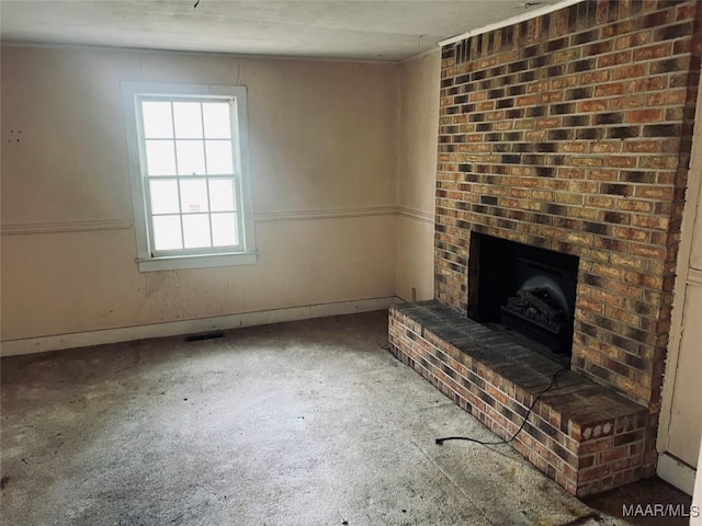 unfurnished living room featuring carpet flooring, visible vents, and baseboards