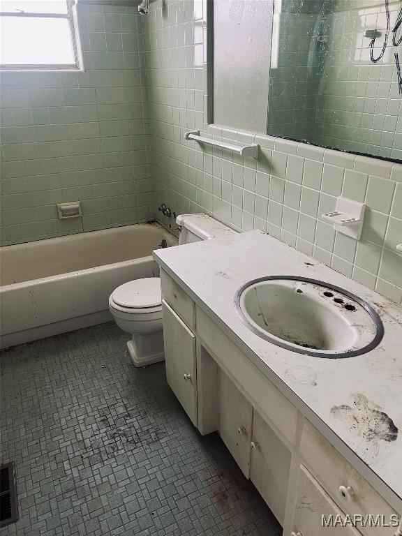 bathroom with bathing tub / shower combination, vanity, toilet, tile walls, and decorative backsplash