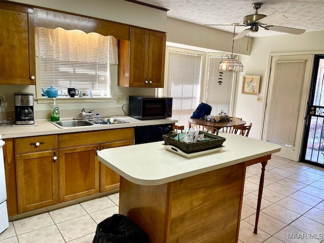 kitchen featuring a sink, a ceiling fan, a kitchen breakfast bar, brown cabinets, and black appliances