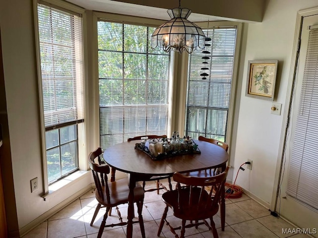 dining space with light tile patterned floors, baseboards, and an inviting chandelier