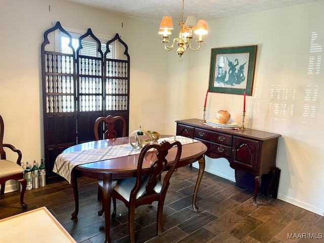 dining space with baseboards, a textured ceiling, an inviting chandelier, and wood finish floors