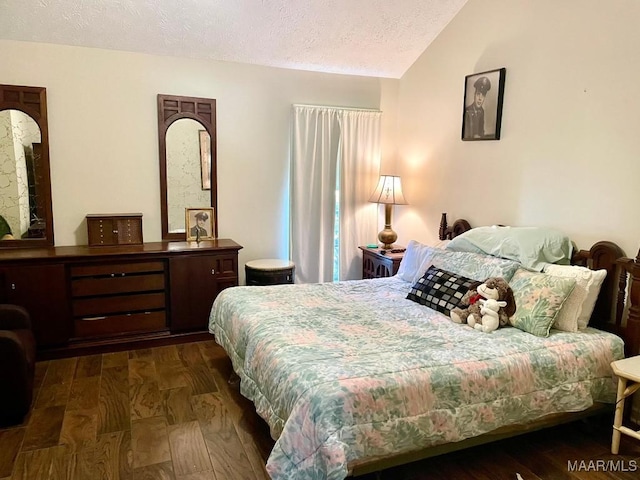 bedroom with a textured ceiling, lofted ceiling, and dark wood finished floors