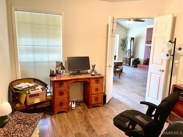 office with light wood-style floors, a textured ceiling, and a ceiling fan