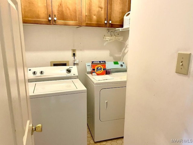 washroom featuring independent washer and dryer and cabinet space