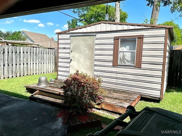 view of home's exterior featuring a fenced backyard, an outdoor structure, and a storage unit