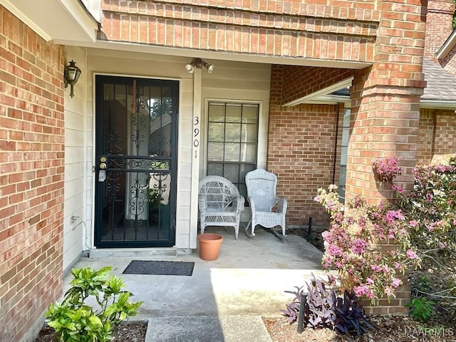 doorway to property featuring brick siding