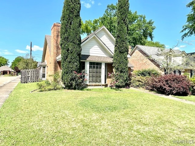 view of front of property featuring a front lawn, fence, and a chimney