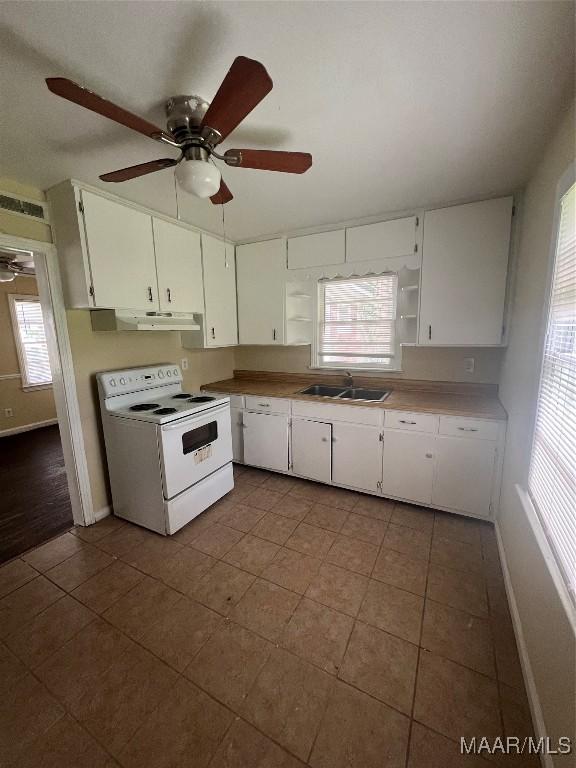 1246 E Audubon Rd, Montgomery, AL 36111 - kitchen with under cabinet range hood, electric range, white cabinetry, and a sink