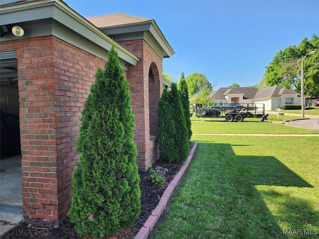 exterior space featuring a yard and brick siding