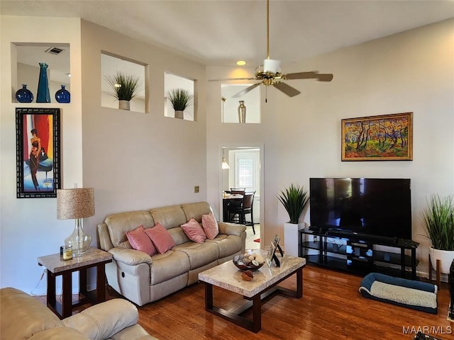living room with visible vents, ceiling fan, and wood finished floors