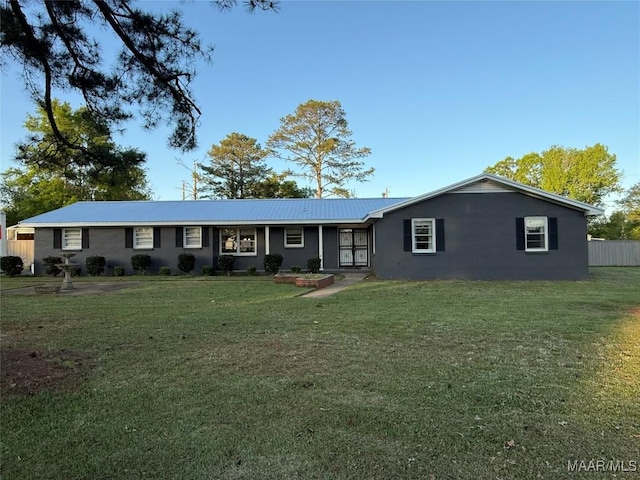 ranch-style home featuring a front lawn, fence, and metal roof