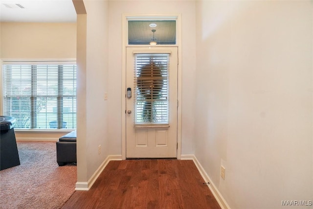 entryway with visible vents, baseboards, arched walkways, and carpet flooring