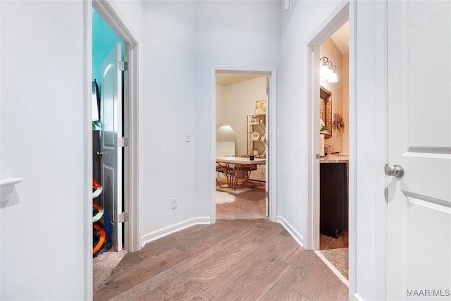 hallway with light wood-style flooring and baseboards