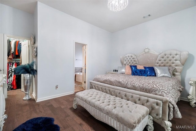 bedroom featuring visible vents, a walk in closet, a closet, and wood finished floors