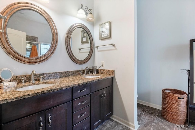full bathroom featuring double vanity, baseboards, and a sink