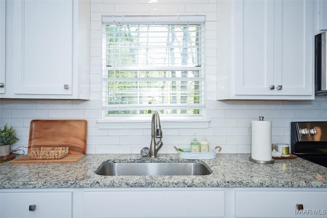 315 Lake Point Dr, Jacksons Gap, AL 36861 - kitchen with a sink, backsplash, and white cabinets