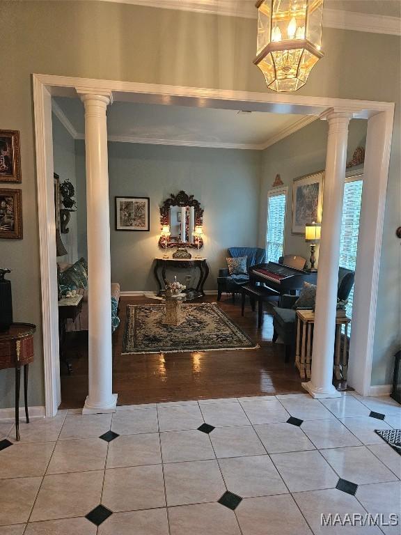 tiled entryway featuring decorative columns and ornamental molding