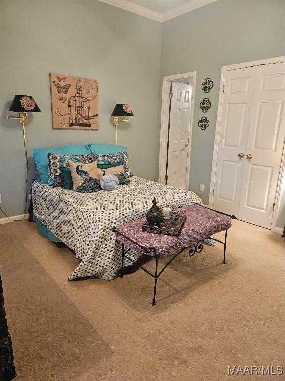 carpeted bedroom featuring crown molding and baseboards