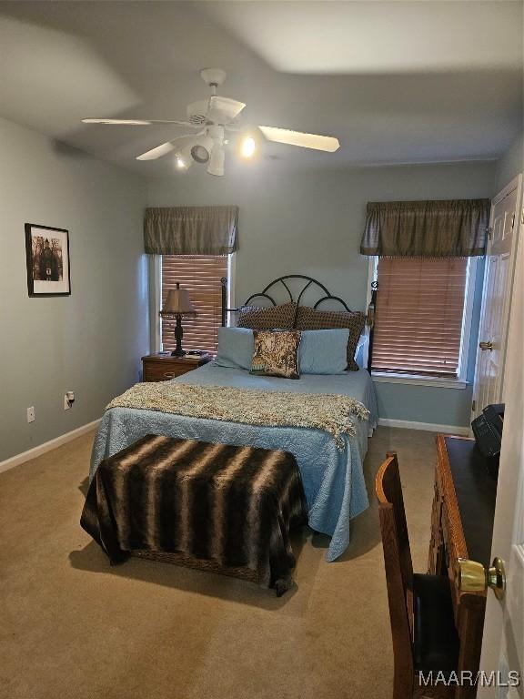 carpeted bedroom with baseboards and ceiling fan