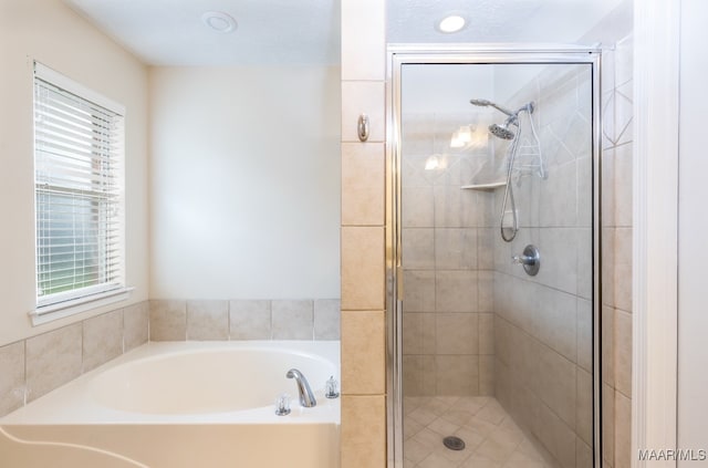 bathroom featuring a shower stall and a garden tub