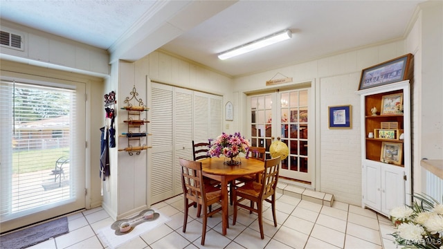 dining space featuring crown molding, visible vents, light tile patterned flooring, and french doors