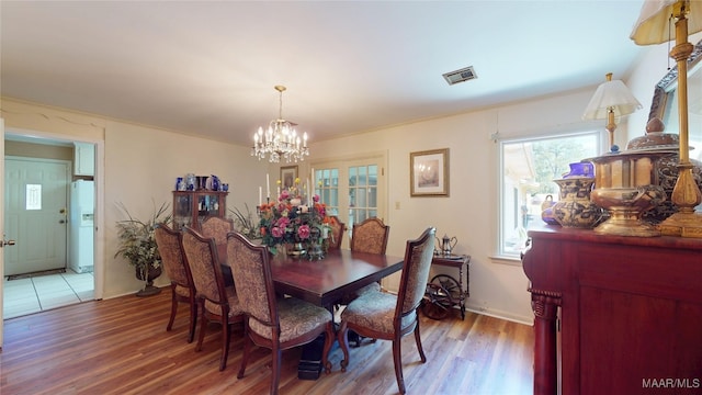 dining area with a chandelier, visible vents, and wood finished floors