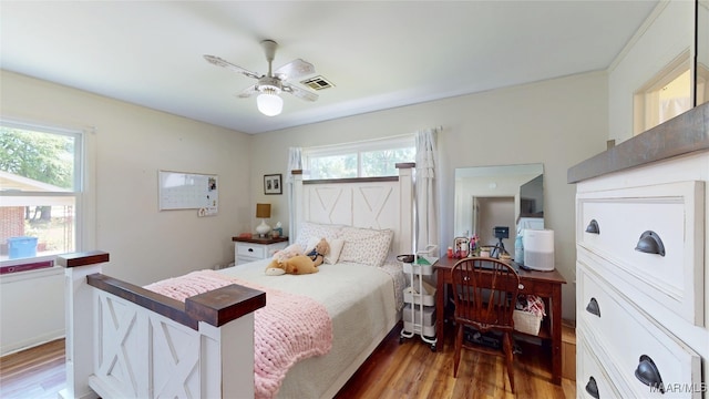 bedroom featuring visible vents, a ceiling fan, and wood finished floors
