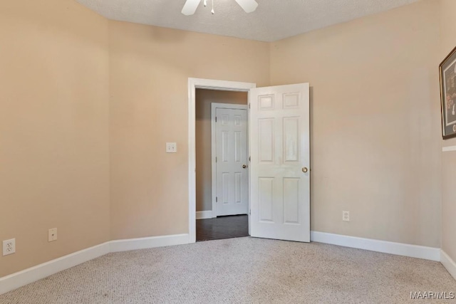carpeted spare room with baseboards and a ceiling fan