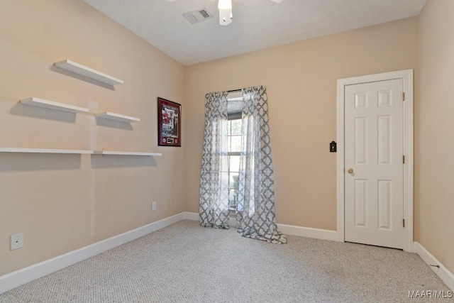 empty room featuring visible vents, ceiling fan, carpet, and baseboards