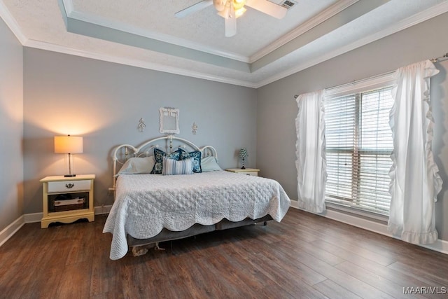 bedroom with crown molding, multiple windows, a raised ceiling, and wood finished floors
