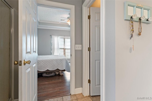 hallway with light tile patterned floors and ornamental molding