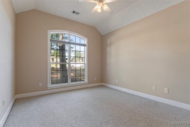 empty room featuring baseboards, vaulted ceiling, visible vents, ceiling fan, and carpet