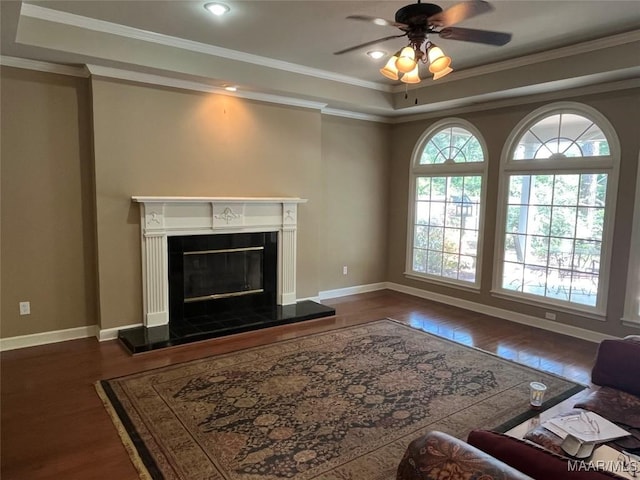 living room featuring dark wood finished floors, baseboards, a glass covered fireplace, and ceiling fan