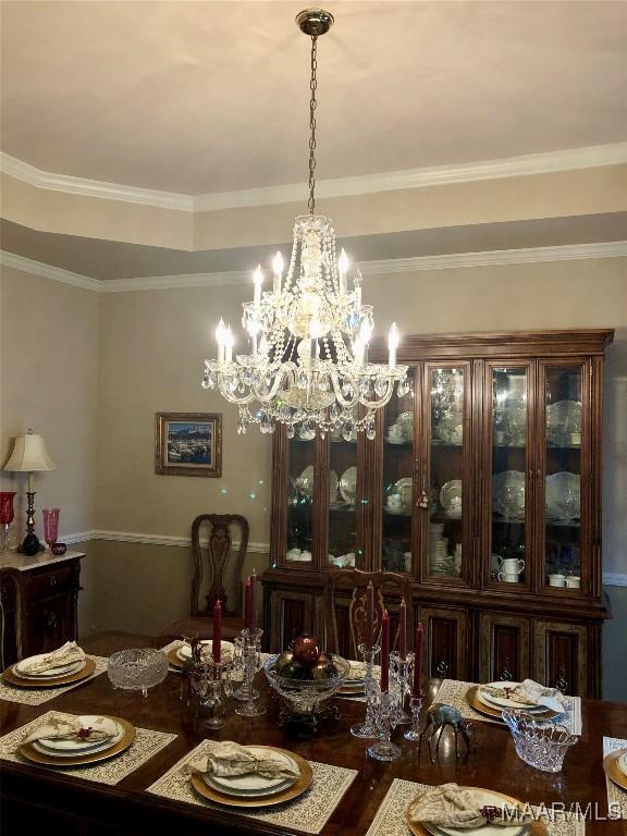 dining room featuring ornamental molding and an inviting chandelier