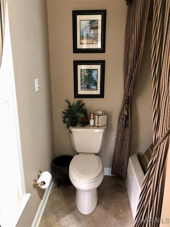 full bathroom with toilet, tile patterned floors, and baseboards