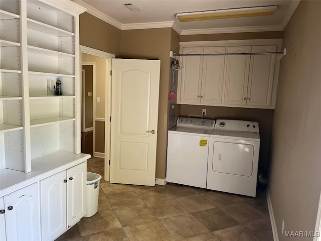 washroom with visible vents, crown molding, baseboards, separate washer and dryer, and cabinet space