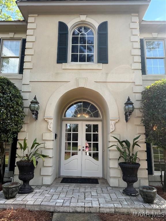 property entrance with french doors and stucco siding