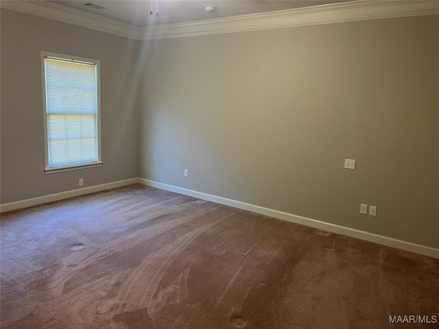 carpeted spare room featuring baseboards and crown molding
