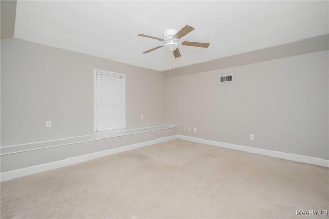 spare room with light carpet, ceiling fan, baseboards, and visible vents