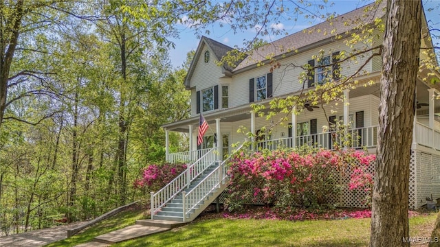 view of front of property featuring a porch, a front lawn, and stairway