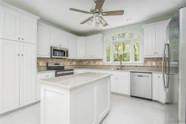 kitchen featuring decorative backsplash, white cabinetry, a sink, and appliances with stainless steel finishes