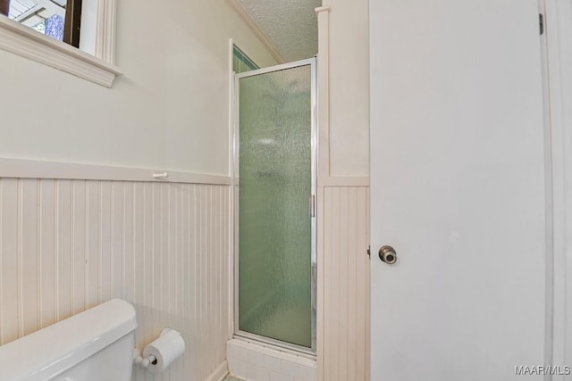 210 Weluvit Ln, Titus, AL 36080 - bathroom featuring toilet, a stall shower, a wainscoted wall, and a textured ceiling
