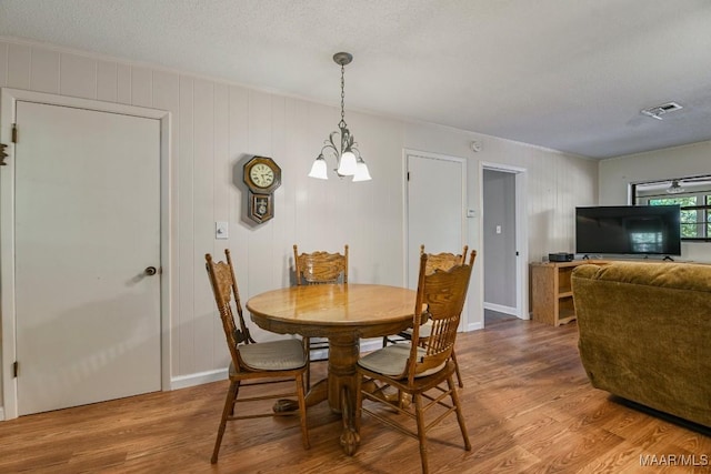 210 Weluvit Ln, Titus, AL 36080 - dining room with wood finished floors, a chandelier, and a textured ceiling