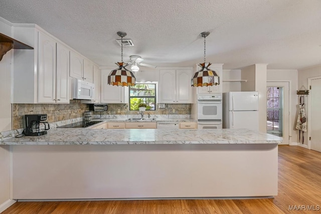 210 Weluvit Ln, Titus, AL 36080 - kitchen featuring white appliances, a sink, a peninsula, light countertops, and decorative backsplash