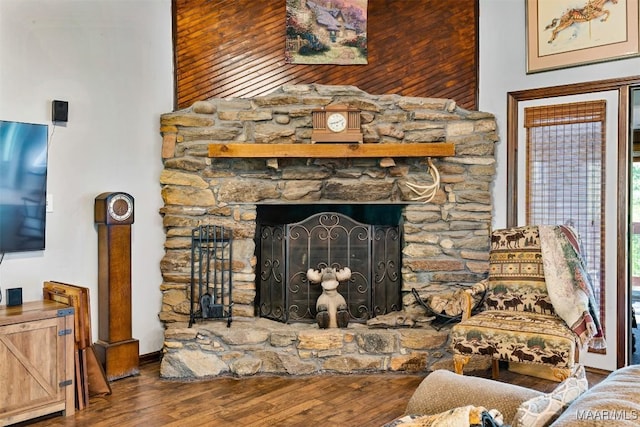 interior details with wood finished floors and a stone fireplace