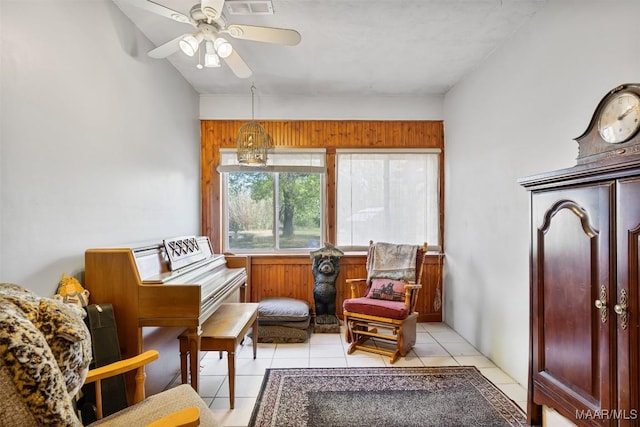 living area with light tile patterned floors and a ceiling fan