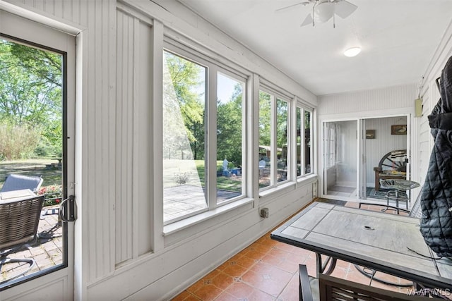 sunroom / solarium featuring tile patterned floors and a ceiling fan