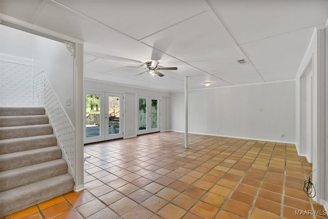 unfurnished living room with a ceiling fan, tile patterned flooring, stairway, french doors, and baseboards