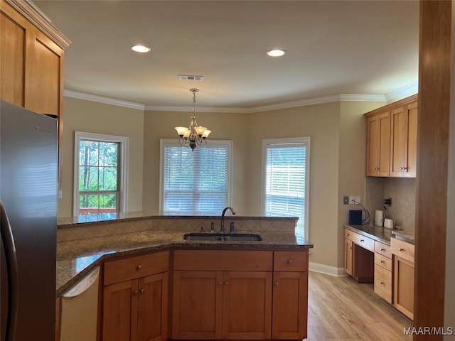 kitchen featuring tasteful backsplash, visible vents, white dishwasher, a sink, and freestanding refrigerator