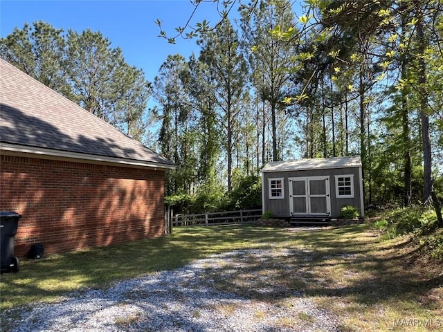 view of yard featuring a storage unit, fence, and an outdoor structure